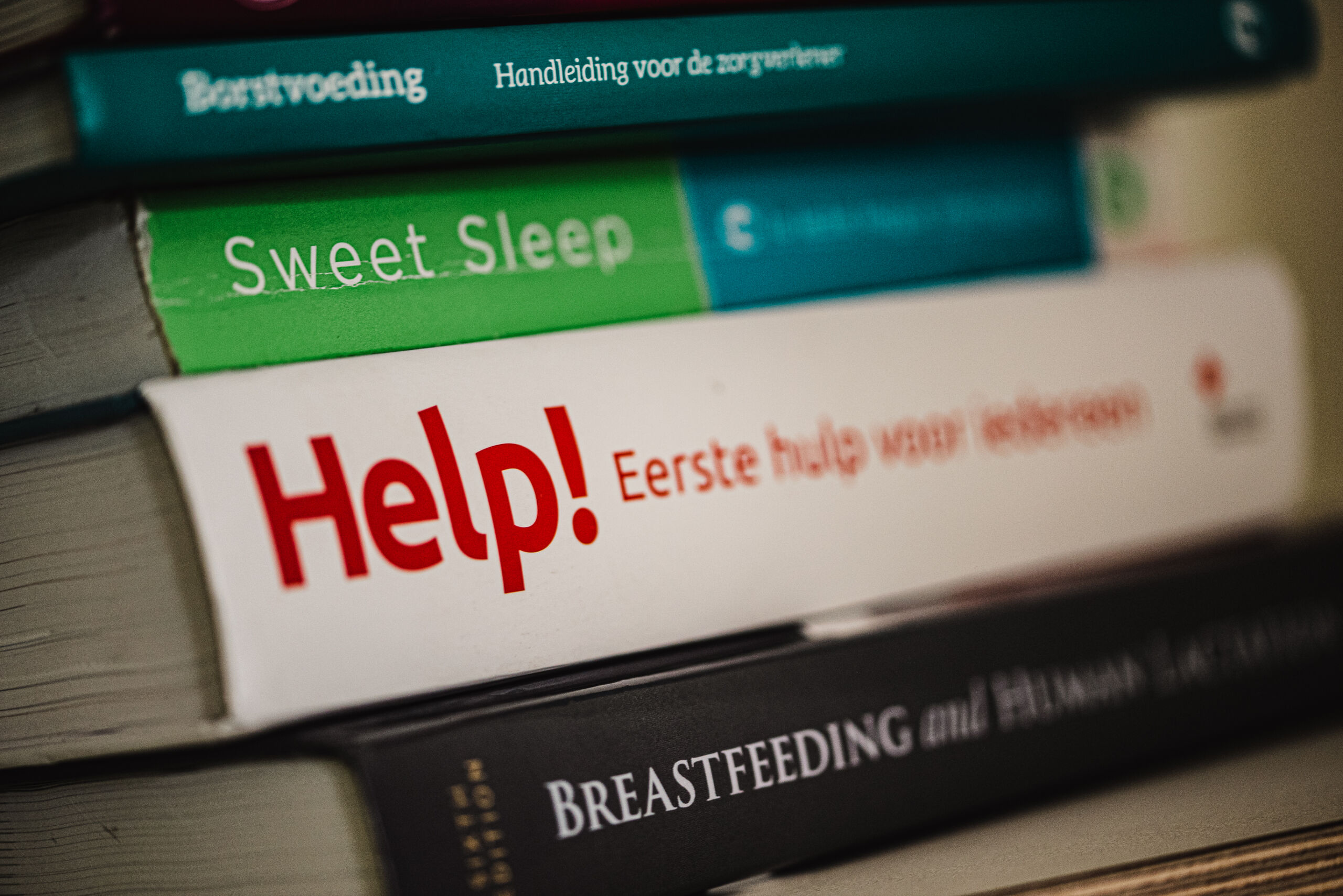 Stapel boeken over borstvoeding, slaap en eerste hulp bij kinderen